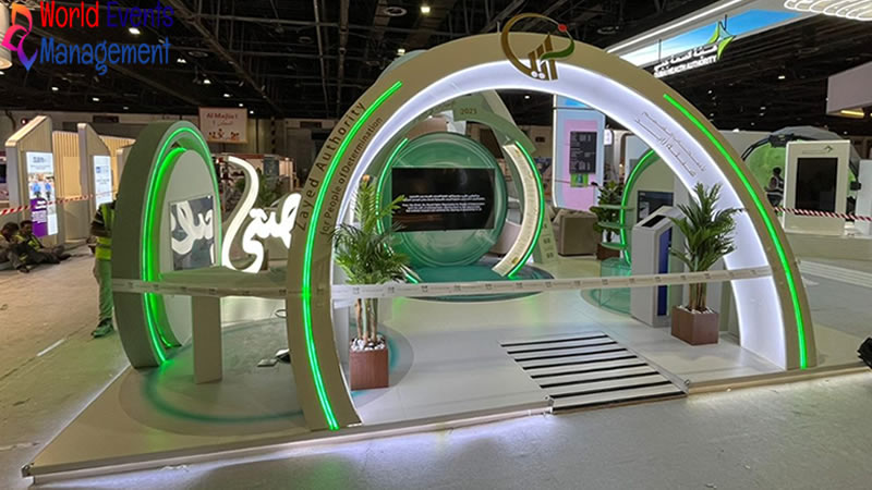 Green circular exhibition stand with curved arches, plants, and futuristic booth design