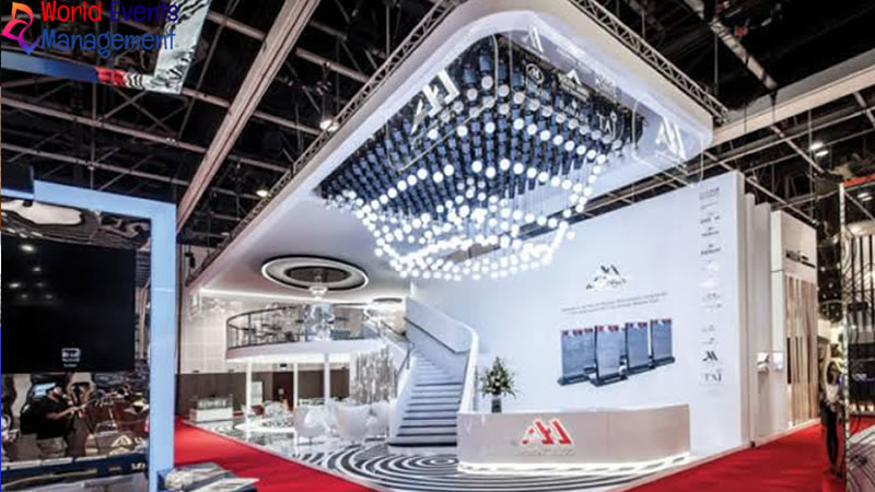 Large contemporary exhibition stand with illuminated ceiling feature and white reception desk