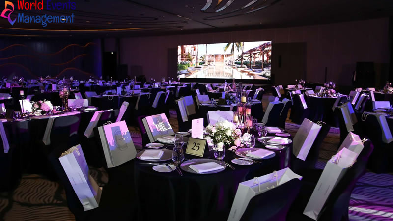 Corporate gala dinner event with stage lighting and elegant seating